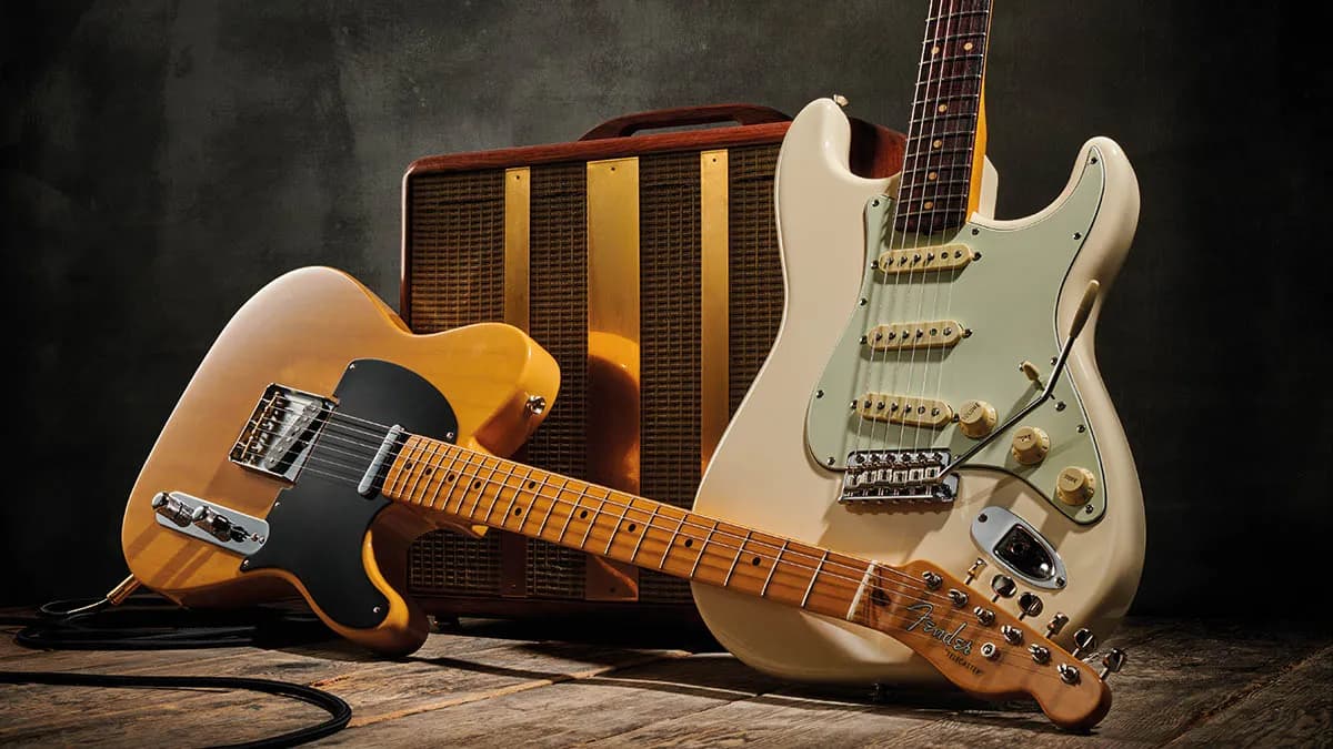 Vintage Fender electric guitars displayed in front of a classic amplifier.