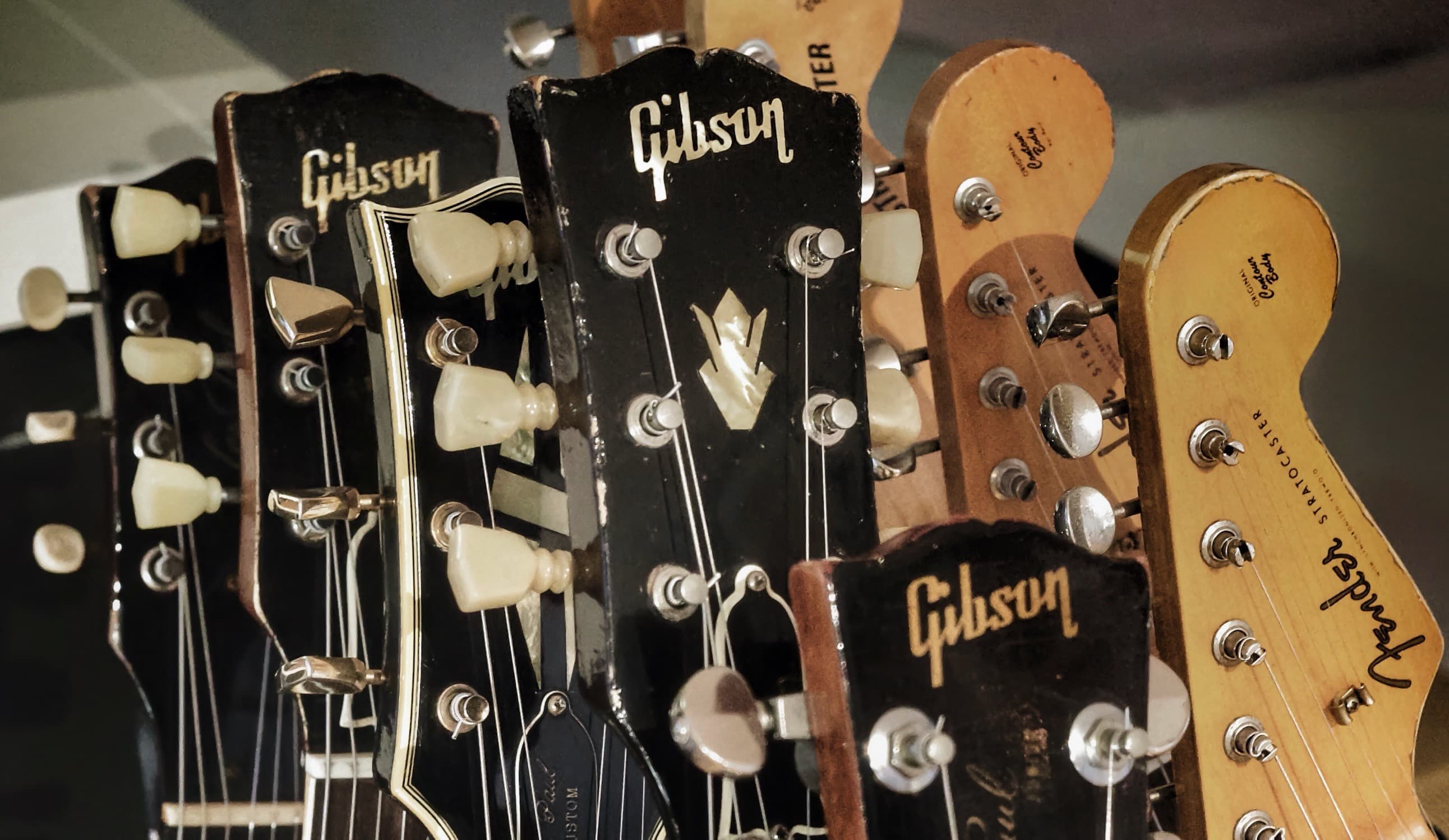 A collection of vintage guitars arranged in a warm studio setting